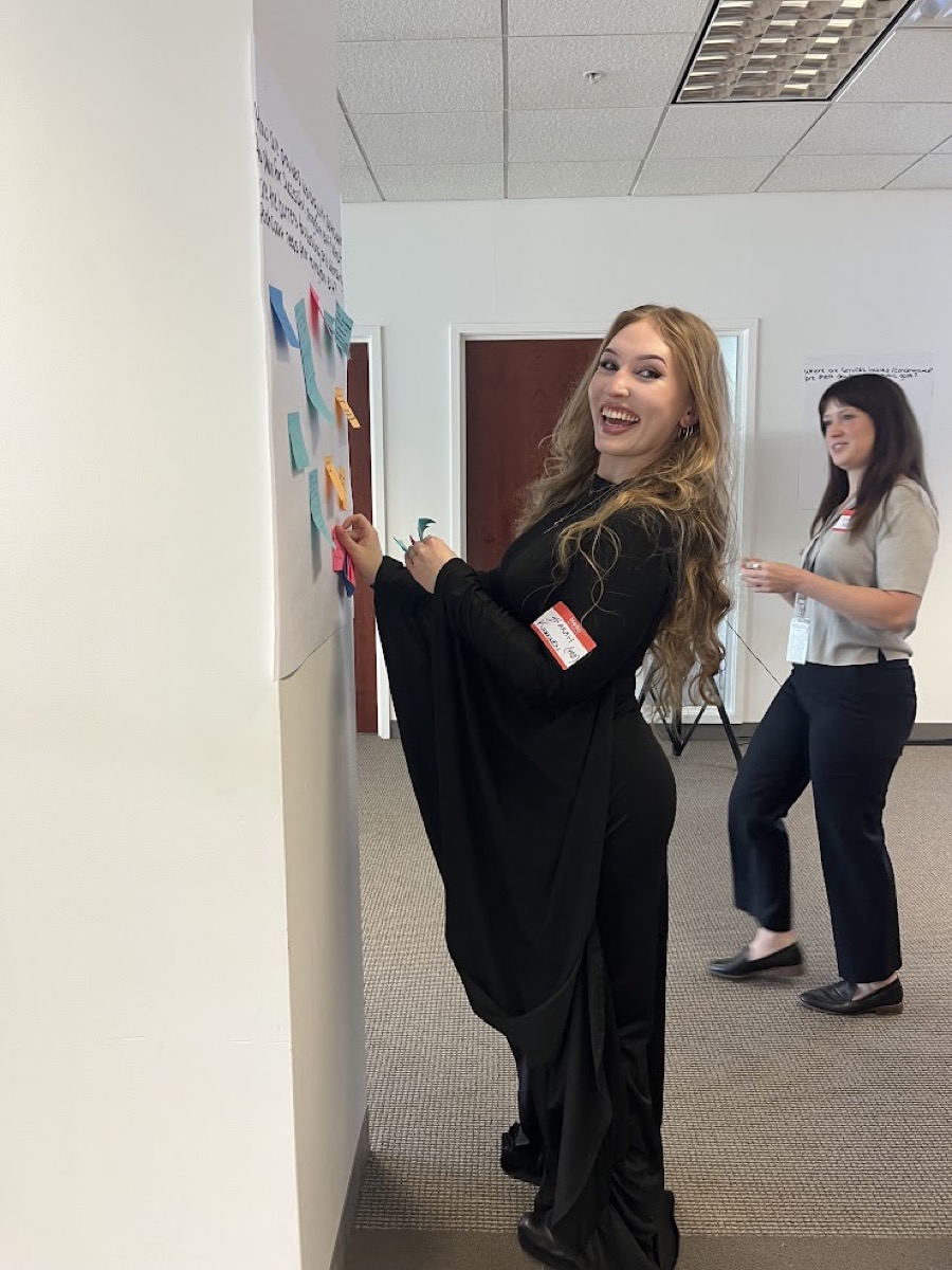 A team member smiles while engaged in a collaborative sticky-note brainstorming exercise during a workshop